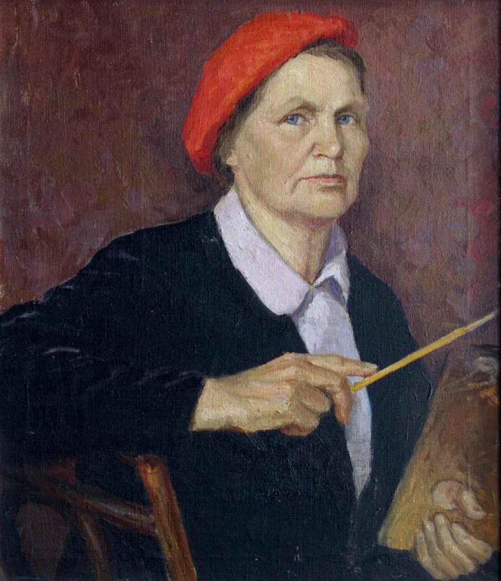 На сиренево-красно-коричневом фоне с мазками изображен поясной портрет женщины в 3/4 повороте. Женщина сидит, облокотившись правой рукой на спинку стула. В правой руке - кисть, в левой – палитра; одета в черный жакет и светло-разовую блузку с отложным воротником, на голове красный берет.
