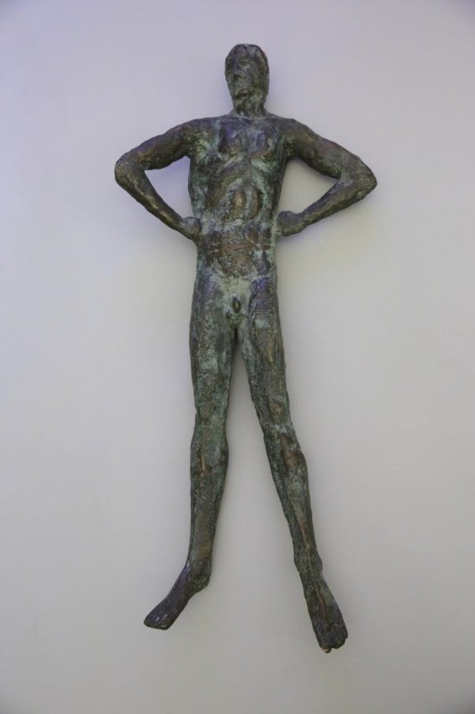 Изображена в рост обнаженная мужская фигура с согнутыми в локтях и упертыми в бока руками. Ноги раздвинуты, голова слегка повернута к правому плечу. Фактурная поверхность скульптуры-патинирована. Скульптура монтируется на болт к основной стойке.