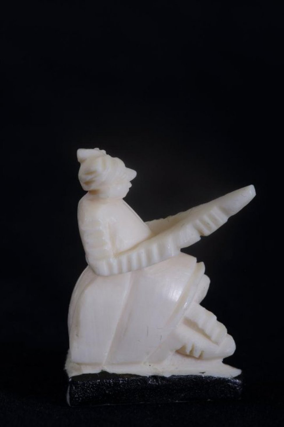 Стоящая на одном колене фигура воина с оружием в форме треугольника в руках. Подставка черная треугольная.