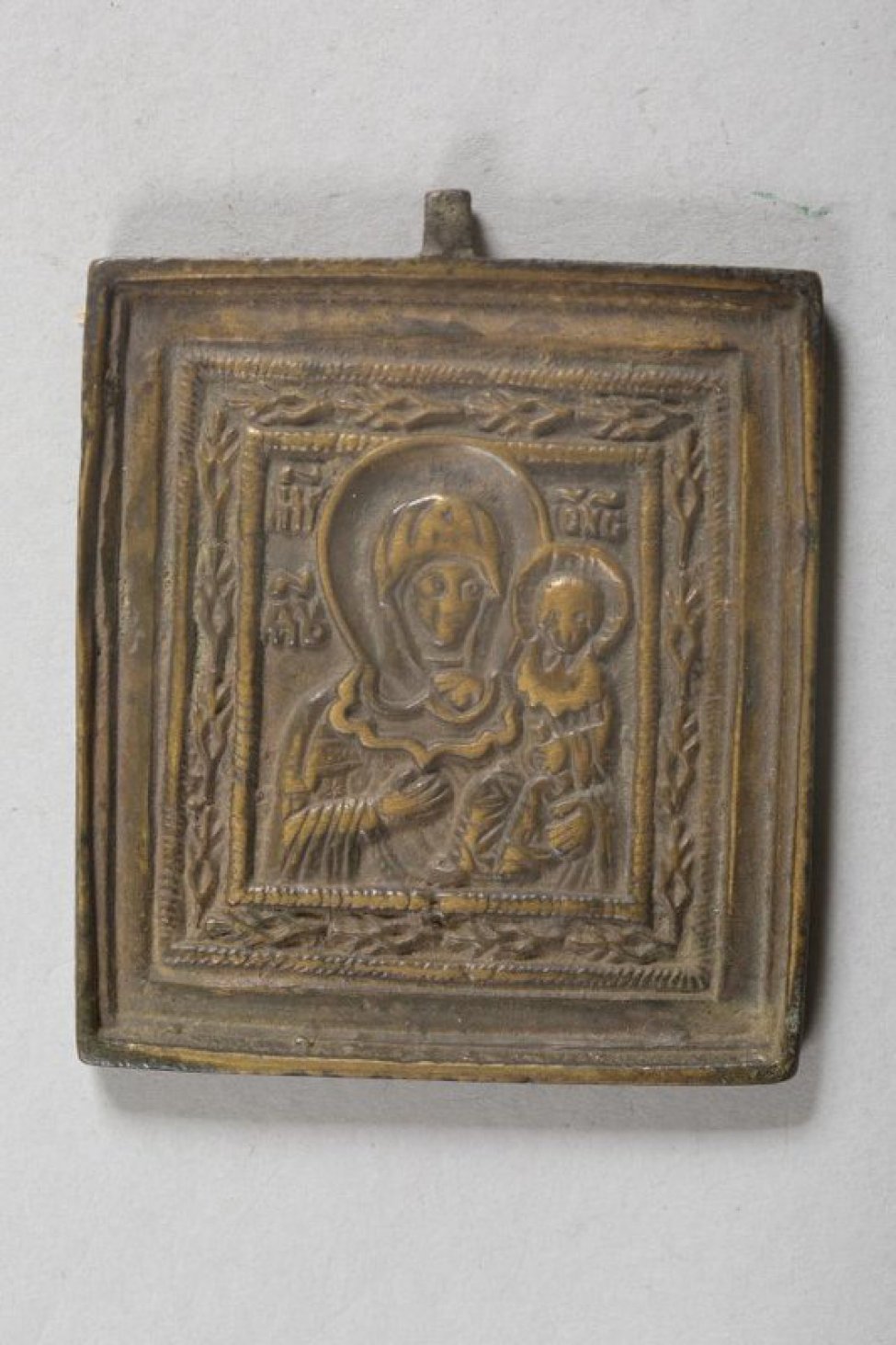 В среднике иконы изображена Богоматерь с младенцем Христом на левой руке, благословляющим правой рукой, а в левой держит свернутый свиток