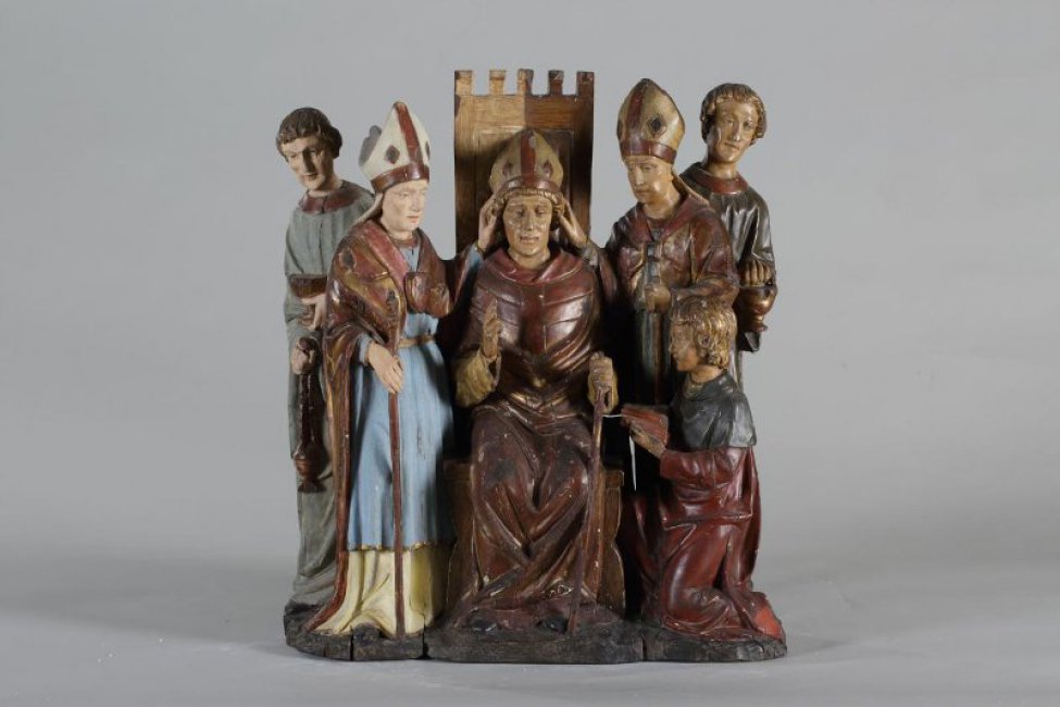 Изображена группа, состоящая из пяти человек, один из них справа, коленопреклоненный, в длинных одеждах с посохом. В центре на троне епископ в длинной одежде с посохом, правая рука поднята для благословения.