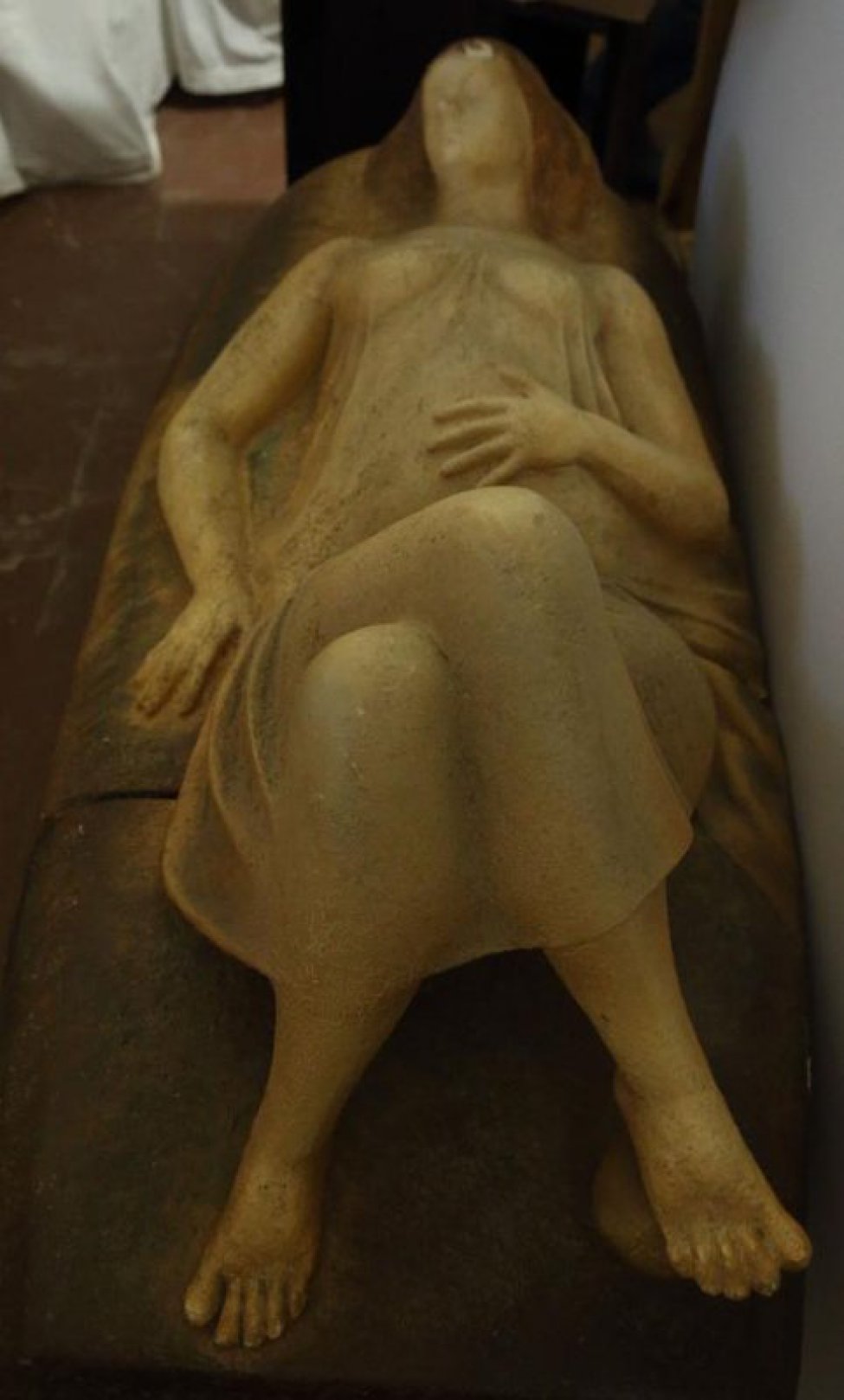 Изображена лежащая беременная женщина, правая рука лежит вдоль скульптуры, левая - на животе. Ноги согнуты в коленях, правая нога закинута на левую.