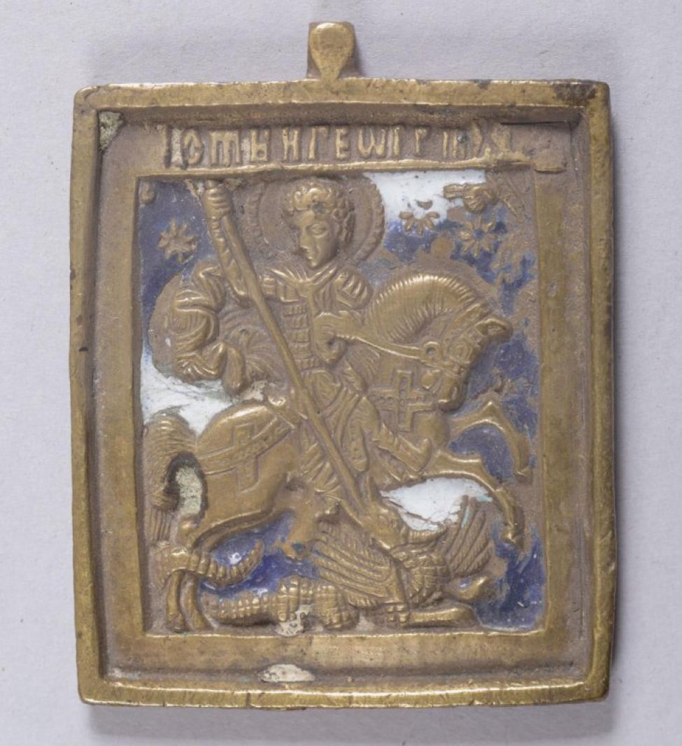 На фоне темно-синей и белой эмали изображение святого Георгия, убивающего змея.